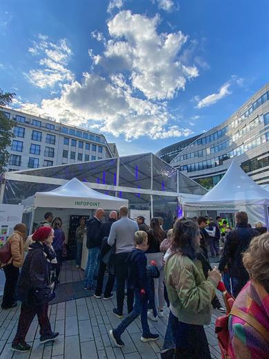 Zahlreiche Besucherinnen und Besucher stehen bei der Nacht der Wissenschaft 2024 auf dem Schadowplatz in Düsseldorf vor den Veranstaltungszelten und dem Infopoint.